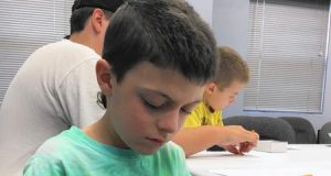 Seven-year-old Henry Heun, of Highland Park, learns how to use a compass during a program at the Great Lakes Naval Museum Saturday.